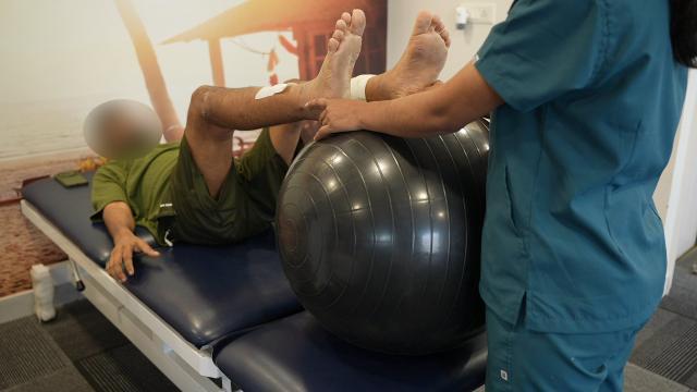 Patient performing gradual weight-bearing exercises after surgery